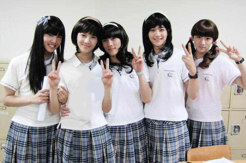 Five SHINee members in school girl uniforms. Left-right: Onew, Taemin, Jonghyun, Minho, Key